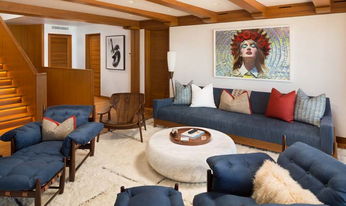 Adjoining lounge with mid-century seating and a large framed portrait above the sofa.